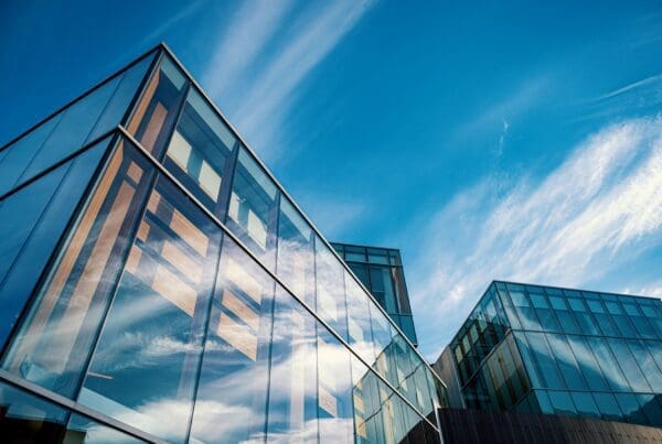 Bâtiment corporatif moderne en verre reflétant le ciel bleu et les nuages